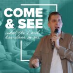 Freedom Cape Town A male pastor, holding a microphone, speaks to a congregation. The title of the sermon series, "COME & SEE what the Lord has done in me," is overlaid on a teal-coloured image of the congregation.