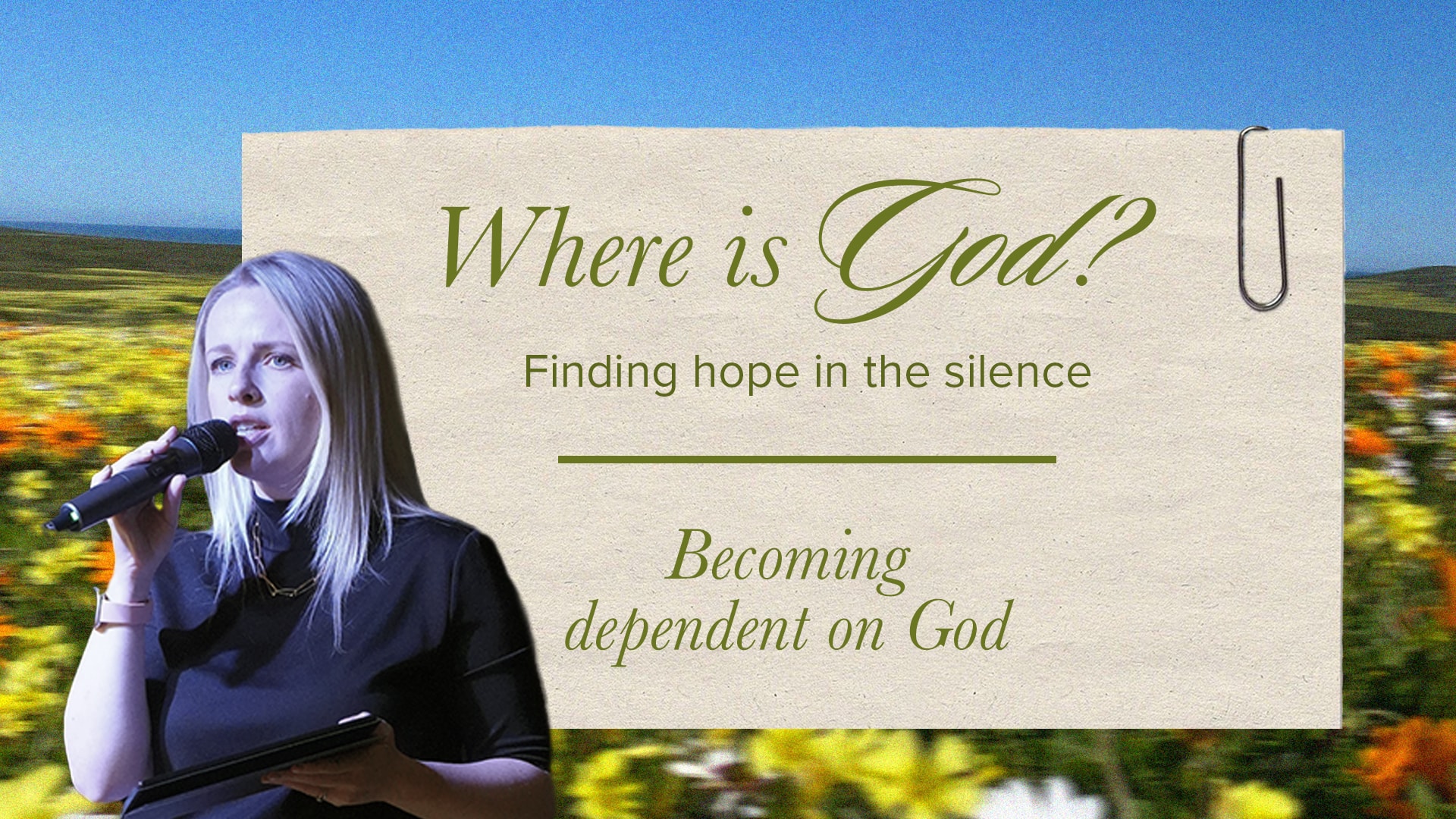 A light-skinned woman with long, straight blonde hair and a black top holds a microphone to her mouth with her left hand and a tablet in her right. She stands in front of a blue sky and a field of yellow and orange flowers. To her right is a paper-like graphic with the words "Where is God? Finding hope in the silence" at the top, and "Becoming dependent on God" at the bottom. A paperclip is visible in the top right corner of the graphic.