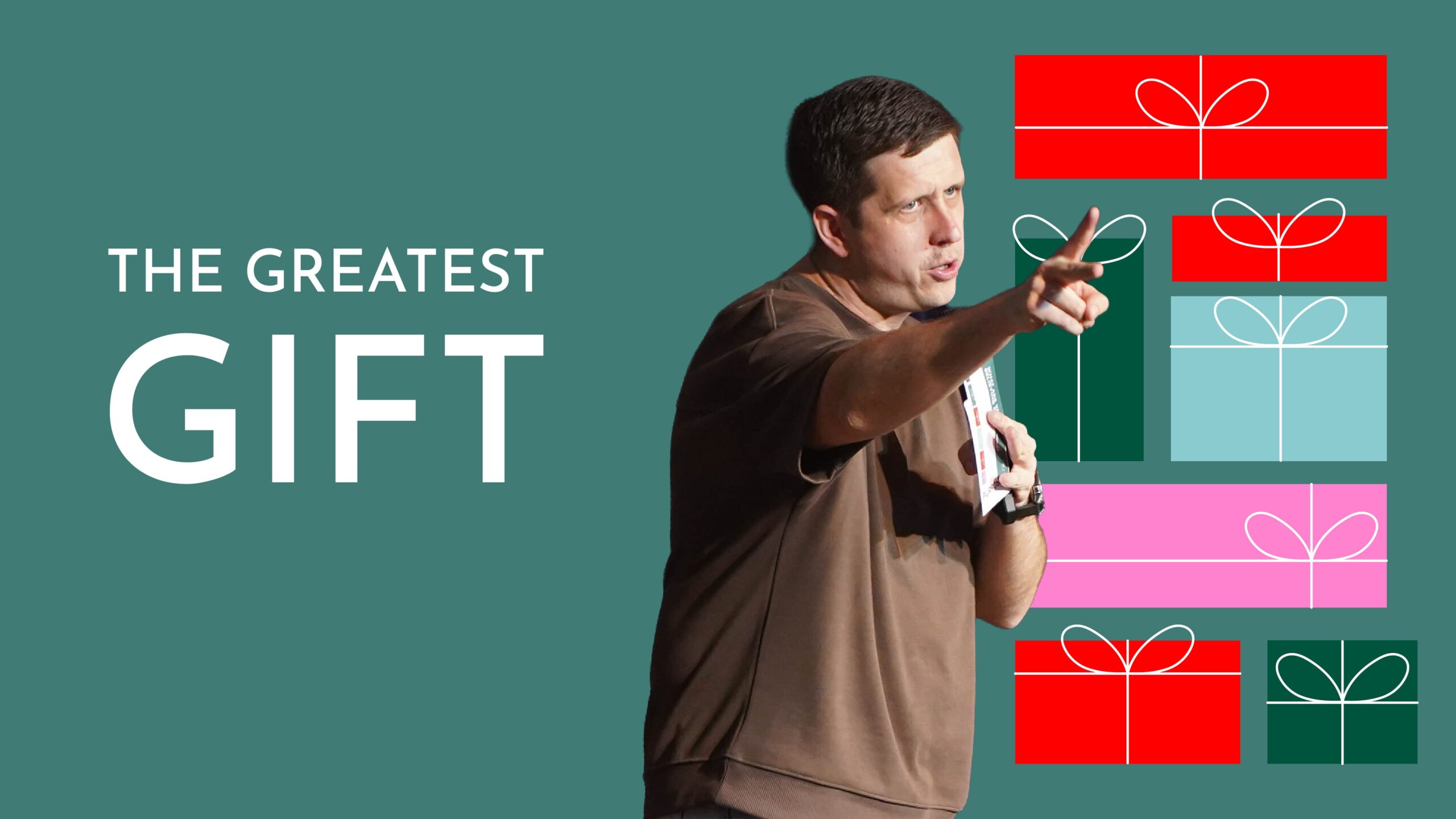 Graphic for a Christmas preach series titled "THE GREATEST GIFT." The image features a man in a brown t-shirt speaking and gesturing forward against a teal background. To his right is a vertical stack of colourful, stylised Christmas gift box illustrations in red, green, pink, and light blue.